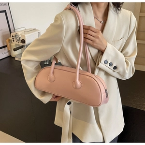 Pink cylinder underarm bag with double straps shown styled with a beige blazer