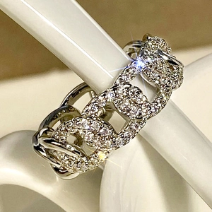 Macro shot of silver chain link ring with pavé set cubic zirconia and polished finish