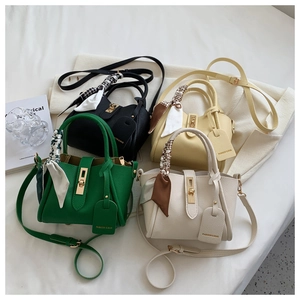 Détail de quatre sacs seaux colorés avec poignées en foulard et fermoirs dorés
