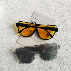 Fashionable oversized semi-rimless sunglasses with tawny and grey lenses in flat lay view