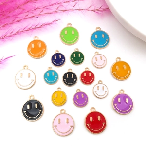 Flat lay of colorful enamel smiley face pendants for DIY jewelry making in various sizes