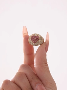 Makroaufnahme von vergoldetem Ring mit rosa Herzsteinen und Pave-Zirkon-Fassung