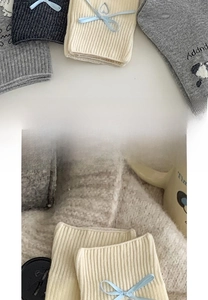 Detail der breiten elastischen Bündchen an grauen Socken mit hellblauen Schleifen