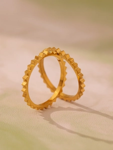 Detail of minimalist 18k gold plated titanium steel gear rings with textured matte finish