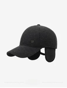 Detail of grey winter baseball cap featuring earflaps and small metal shield badge