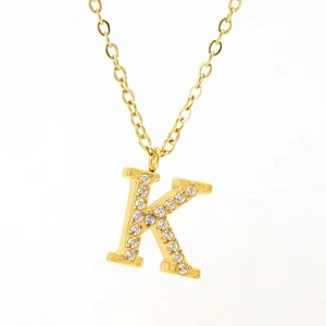 Detailed close-up of a gold-plated necklace featuring a letter K pendant with inset crystals