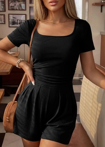 Detail of square neck black ribbed knit romper featuring a fitted waist and short sleeves