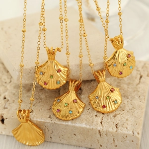 Goldene Muschelkette mit bunten Strasssteinen auf Marmorhintergrund für Damen