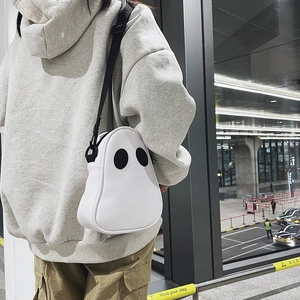 Street style view of a cute white ghost PU leather crossbody bag with adjustable strap
