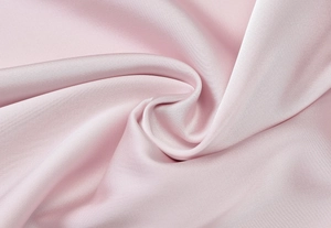 Close-up of pink silk satin fabric showing smooth texture and soft natural draping