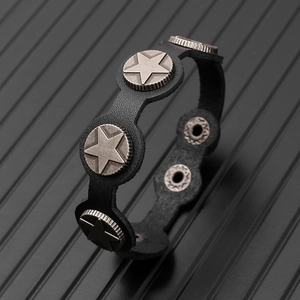 Close-up of black genuine leather bracelet with vintage metal star rivets and snap closure
