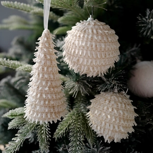 Creamy white plush Christmas tree and ball ornaments with glitter on green branches
