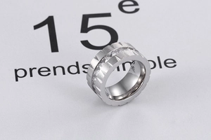 Detail of silver titanium wide ring with gear edge and square cubic zirconia stones