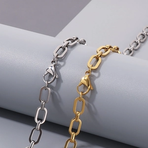 Büroklammer-Halsketten aus Edelstahl in Gold und Silber auf minimalistischen Requisiten