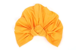 Detail of soft elastic orange knotted turban hat showing fabric texture and knot design