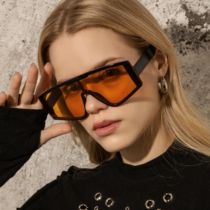 Fashion oversized one-piece sunglasses with black frame and orange lenses for outdoor street style