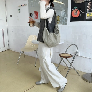 Sage green pleated crossbody bag styled in a casual street fashion outfit