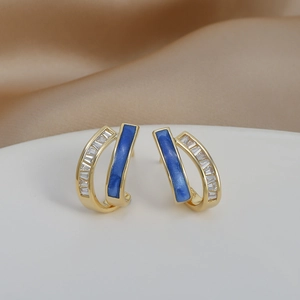 Detail of C-shaped double-layer gold earrings with blue marble enamel and rectangle zircons