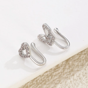 Detail of silver U-shaped non-pierced nose rings with butterfly and heart crystal studs