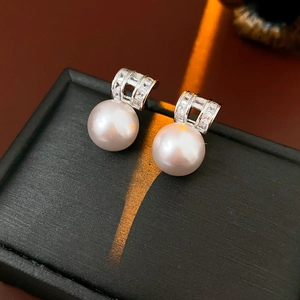 Close-up of pearl drop earrings with cubic zirconia on a black jewelry box