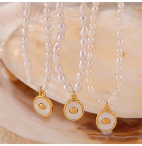 Detail of baroque pearl necklace with golden shell pendant on natural seashell background