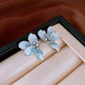 Macro shot of blue butterfly earrings with faux crystal stones and silver needles
