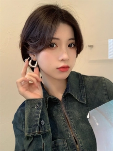 Gros plan d'une boucle d'oreille en U argentée polie portée par un mannequin pour un look sobre