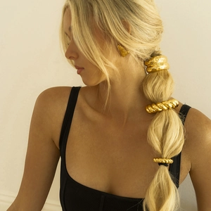 Minimalist gold spiral hair rings and geometric triangle earrings on a ponytail