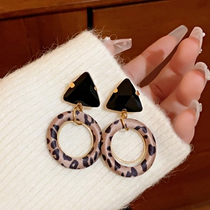 Detail of square pearl earrings with rhinestones and leopard print fabric wrapping