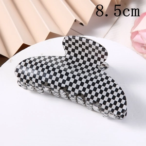 Detail view of 8.5cm checkerboard hair claw clip on a stylish display stand