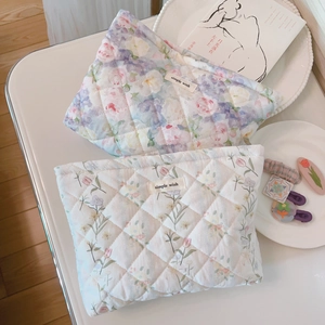 Detail of floral quilted cotton makeup bags with diamond stitching and woven label