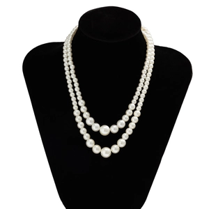 Close-up of double-layer beaded pearl necklace with heart pendant on black velvet mannequin