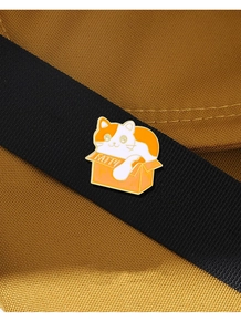 Close-up of enamel cartoon cat brooch with FATTY lettering on a black ribbon strap