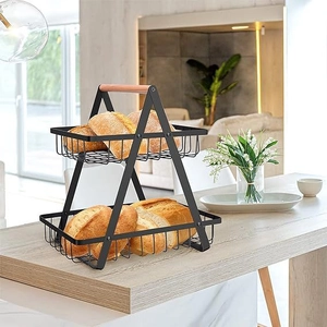 Close-up of double-tier black iron fruit basket with a wooden handle for bread storage