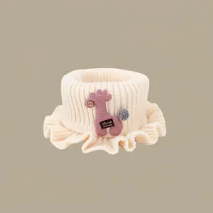 Detailed close-up of cream knit baby neck warmer with cute purple giraffe patch