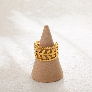Detail view of a 18K gold-plated leaf-shaped adjustable ring on a display cone