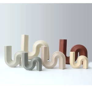 Close-up of modern fluted ceramic vases in Morandi earthy tones with wavy textures