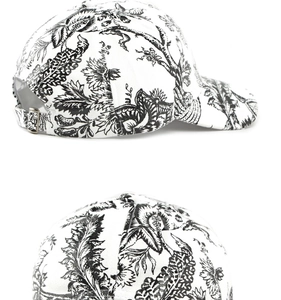 Close-up of black and white Toile de Jouy floral baseball cap with metal buckle