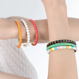 Colorful enamel and gold-plated titanium steel bangles showcased on a female model wrist