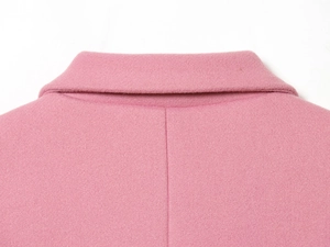 Dettaglio del colletto di un blazer rosa in lana con cuciture e texture di alta qualità