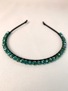 Detail of handcrafted dark green multifaceted beads wrapped on a black slim headband