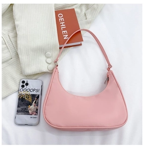 Close-up of pink nylon crescent hobo bag featuring smooth texture and silver metal zipper