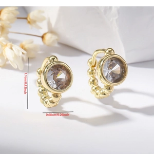 Macro shot of gold hoop earrings with clear zircon stones and size measurement details
