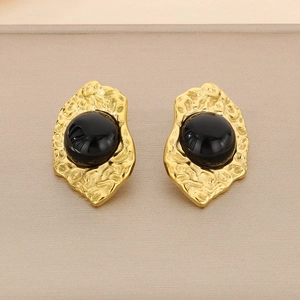 Macro view of 18K gold-plated irregular textured earrings with black stone inlay