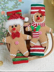 Close-up of plush gingerbread man Christmas ornaments in a rustic wooden basket