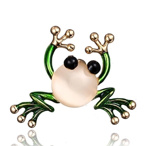Detail einer grünen Froschbrosche mit Goldfinish und großem beigen Kunst-Edelstein