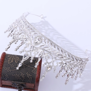 Detailed view of luxury silver bridal tiara with sparkling crystals on a vintage chest