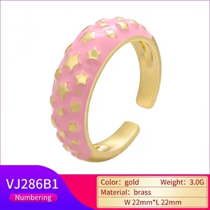 Detailed macro of a gold brass ring with pink enamel coating and star patterns