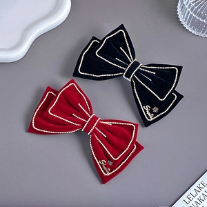 Detailed close-up of velvet bow hair clips with rhinestones and metal accents