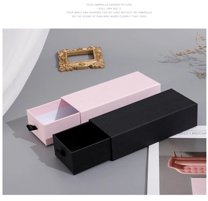 Detail of drawer-style jewelry boxes in pink and black with ribbon pull tabs